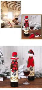 Detailed view of red Christmas hat and plaid scarf accessories for wine bottle decoration
