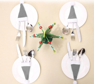 Grey Christmas hat cutlery holder set on plates with a festive tabletop decoration