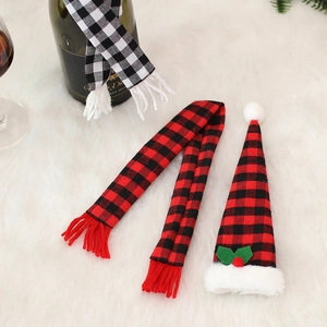 Detail of Christmas plaid wine bottle covers with mini scarves and hats on faux fur