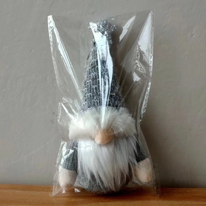 Detail of Christmas gnome plush with gray knitted hat and sparkling silver star decoration