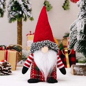 Christmas gnome doll with red knitted hat and plaid body decoration on snow background