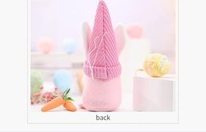 Vista trasera del gnomo de Pascua rosa con gorro de punto y orejas de conejo en soporte