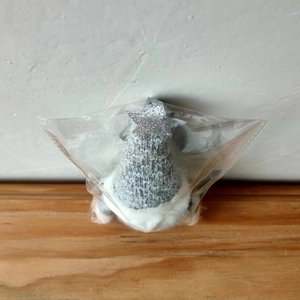 Detail of Christmas gnome pendant with grey knit hat and silver glitter star in packaging