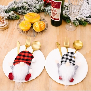 Christmas gnome cutlery holder set with red and white plaid hats on a wooden table