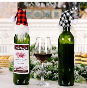 Detail of red and black plaid gnome wine bottle covers on a festive dinner table