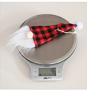 Macro view of a 4.6g Christmas gnome decoration with red and black buffalo plaid hat