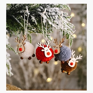 Set of four colorful felt reindeer ornaments hanging on snow-covered Christmas tree branches