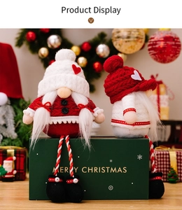Detail view of two Christmas gnome plush dolls sitting on a Merry Christmas gift box