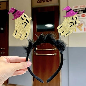 Close-up of Halloween headband with black feathers and shaking gold glitter ghosts