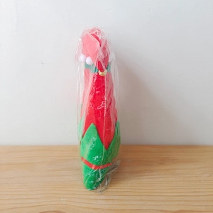 Détail du chapeau de lutin de Noël rouge et vert avec pompons blancs et clochette