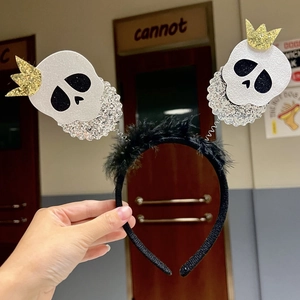 Detail of Halloween headband featuring black feathers and white glitter skulls with crowns