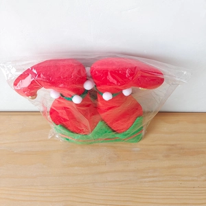 Détail du chapeau de lutin de Noël en velours rouge et vert avec des cloches dorées
