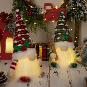 Close-up of lighted Christmas gnomes with warm LED glow and festive knit hats