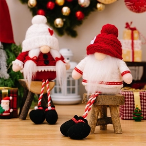 Close-up of plush long-legged Christmas gnomes on wooden blocks in a cozy home setting