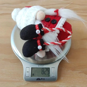 Detailed view of handmade Christmas gnome weight measurement on a scale showing 8.29g