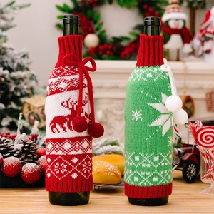 Close-up of knit Christmas wine bottle covers with reindeer and snowflake patterns