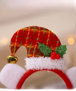 Close-up of Christmas headband with plaid mini hat, gold bell, and green holly leaves