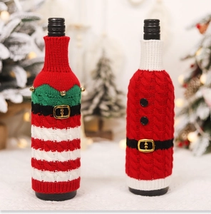 Close-up of knitted Christmas wine bottle covers with belt buckles and bells