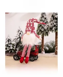Christmas gnome plush doll sitting on a vintage red car model with snowy pine trees detail