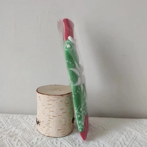Detail view of knitted Christmas bottle cover with snowflake pattern in plastic packaging