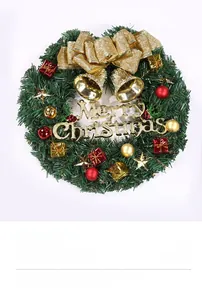 Close-up of Christmas wreath with golden Merry Christmas sign and red festive ornaments