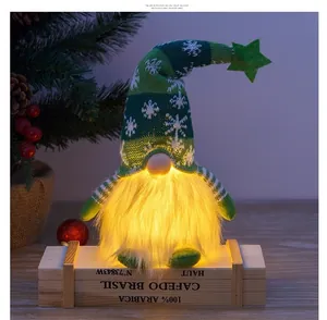 Close-up of a glowing Christmas gnome featuring a snowflake knit hat and warm LED lights