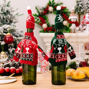 Detail von roten und grünen gestrickten Weinflaschenhüllen im Weihnachtspullover-Design