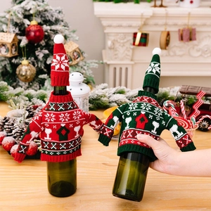 Nahaufnahme von gestrickten Weinflaschenhüllen mit weihnachtlichen Motiven für den Tisch