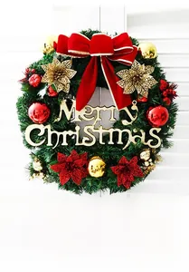 Close-up of a Christmas wreath with a red velvet bow and golden Merry Christmas sign