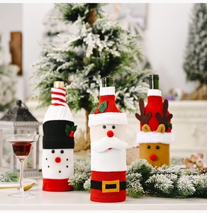 Three Christmas knitted wine bottle covers featuring Santa, snowman, and reindeer figures