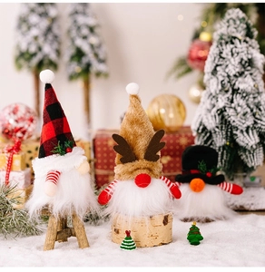 Detailansicht von drei festlichen Weihnachtswichteln mit Mützen und Plüschbärten im Schnee