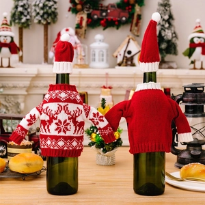Close-up of festive knitted wine bottle covers with reindeer and snowflake patterns