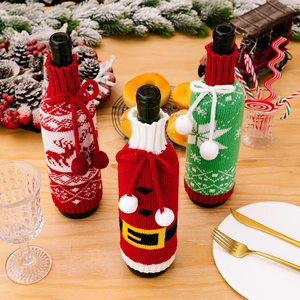 Three-piece knitted Christmas wine bottle covers featuring reindeer and snowflake patterns
