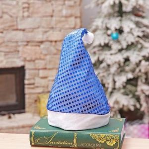 Blue sequin Christmas hat with white plush trim and pompom displayed on a vintage book