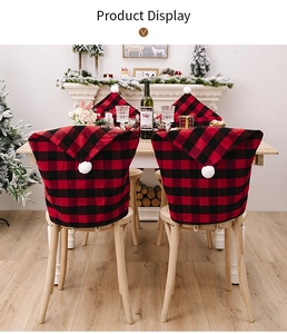 Detail of red and black buffalo plaid Christmas chair covers with white pom-poms