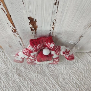 Close-up of red and white knit Christmas wine bottle cover with a pom-pom hat