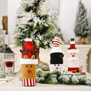 Three Christmas knitted wine bottle covers featuring Santa, reindeer, and snowman designs