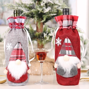 Close-up of festive Christmas gnome wine bottle covers with red and grey linen texture