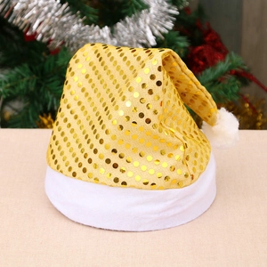 Sparkly gold sequin Christmas Santa hat with white plush trim against a festive tree
