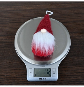 Detailed view of a lightweight 11.2g Christmas gnome ornament on a digital scale