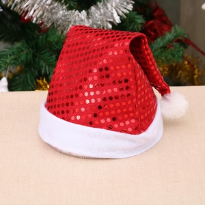 Classic red sequin Christmas hat with white plush trim against a festive tree background
