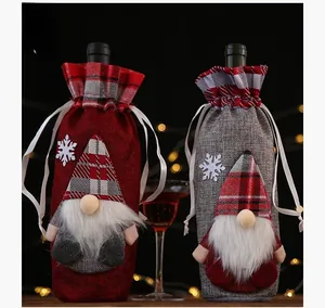 Close-up of Christmas gnome wine bottle covers with rustic burlap and snowflake patterns
