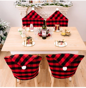 Detail view of red and black buffalo plaid Christmas chair covers with festive white pom-poms