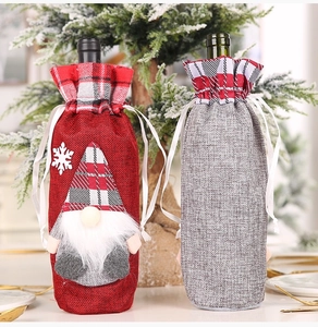 Detail of burlap Christmas gnome wine bottle covers with drawstring and plaid trim