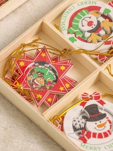 Close-up of wooden Christmas ornaments with snowman and elk prints in a wooden box
