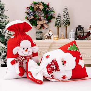 Close-up of knitted Christmas gift bags with 3D snowman and Santa Claus plush details