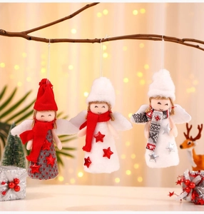 Trois anges de Noël en peluche avec bonnets en tricot et ailes dans un décor festif chaleureux