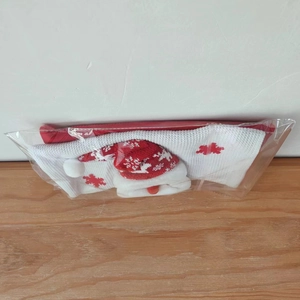 Detailed view of red and white knitted Christmas gift bag with Santa Claus motif
