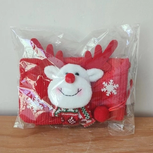 Detail of red Christmas knit bag with plush reindeer head and white snowflake pattern