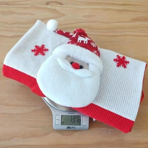 Detail of knitted Santa gift bag on scale showing 137g weight and red snowflake pattern